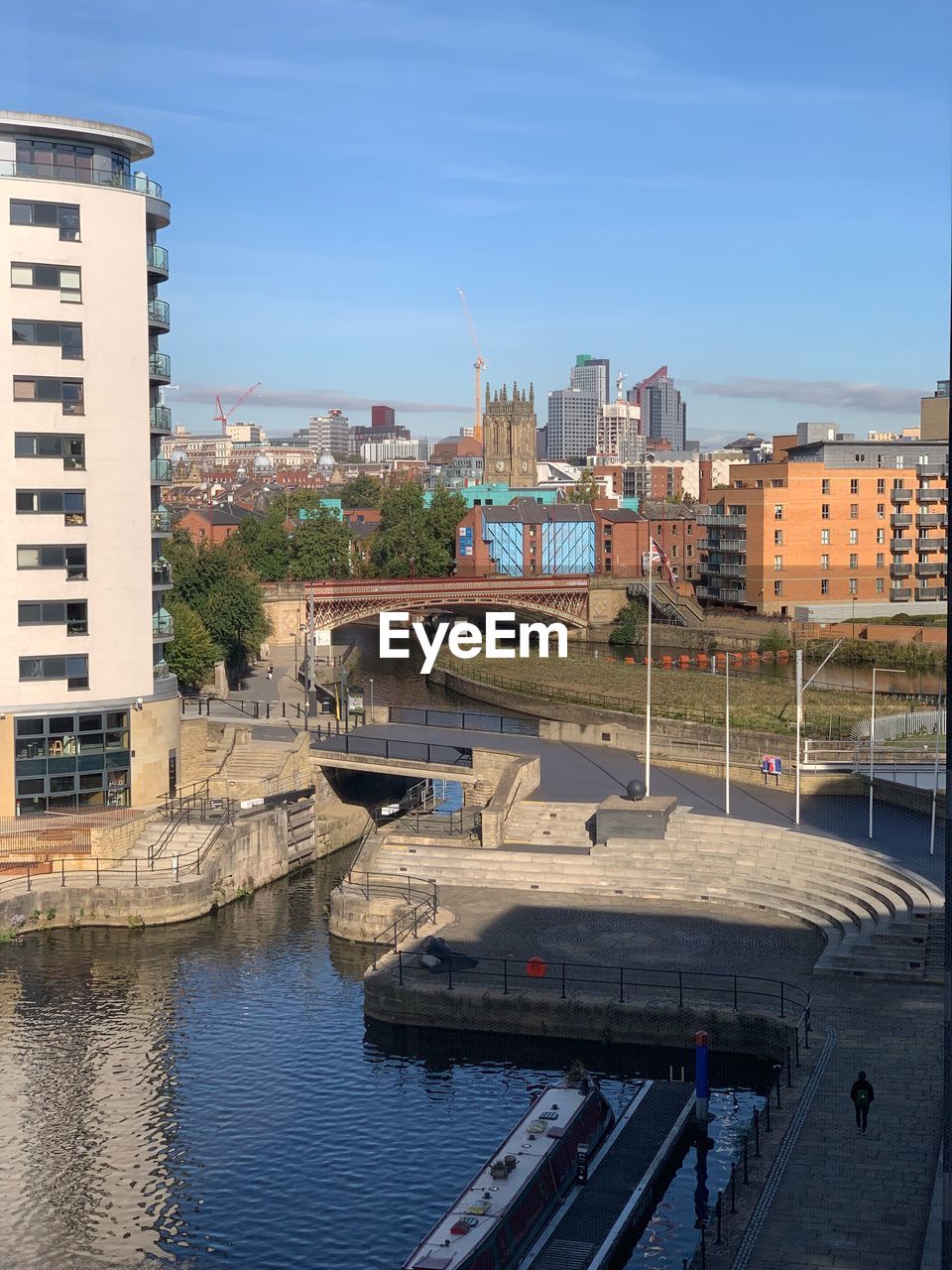 RIVER AMIDST BUILDINGS AGAINST BLUE SKY