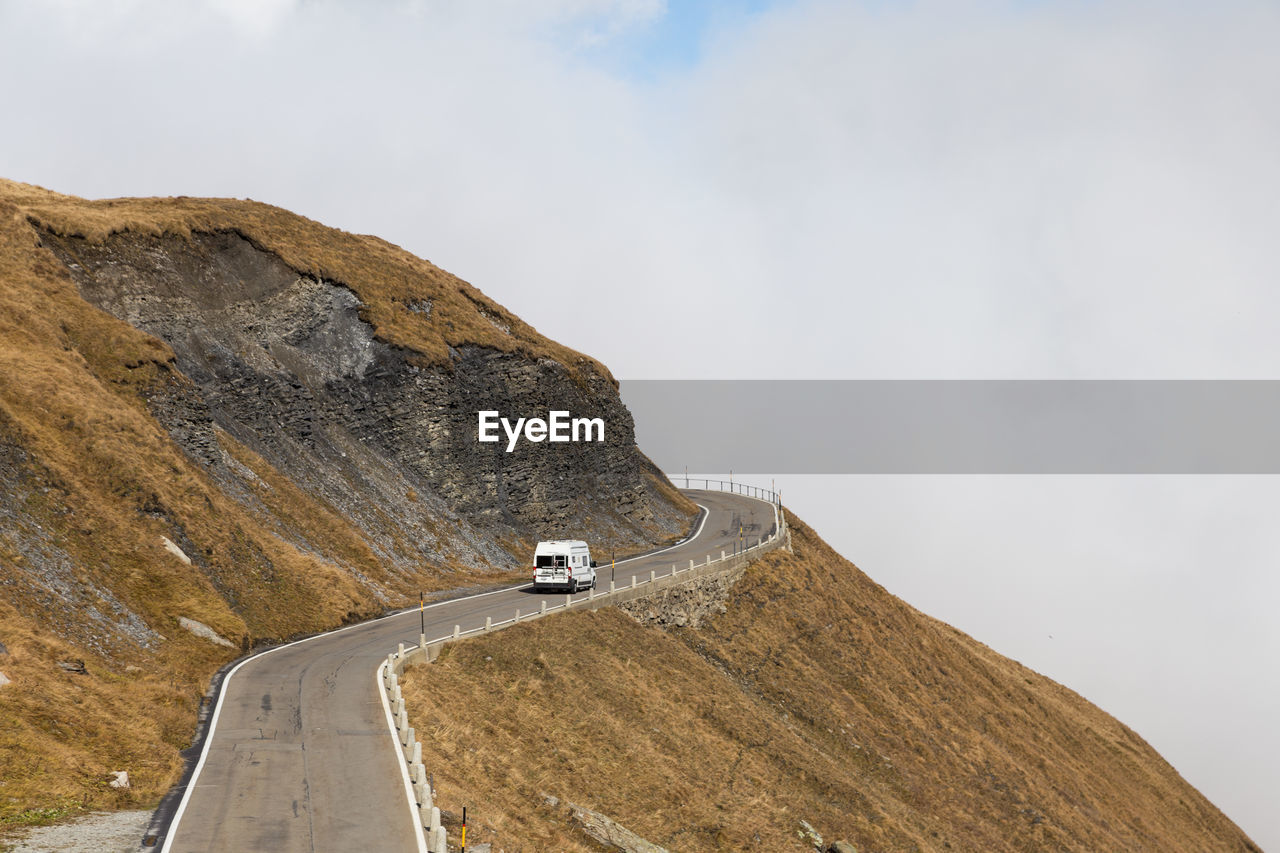 Car on road by mountain against sky