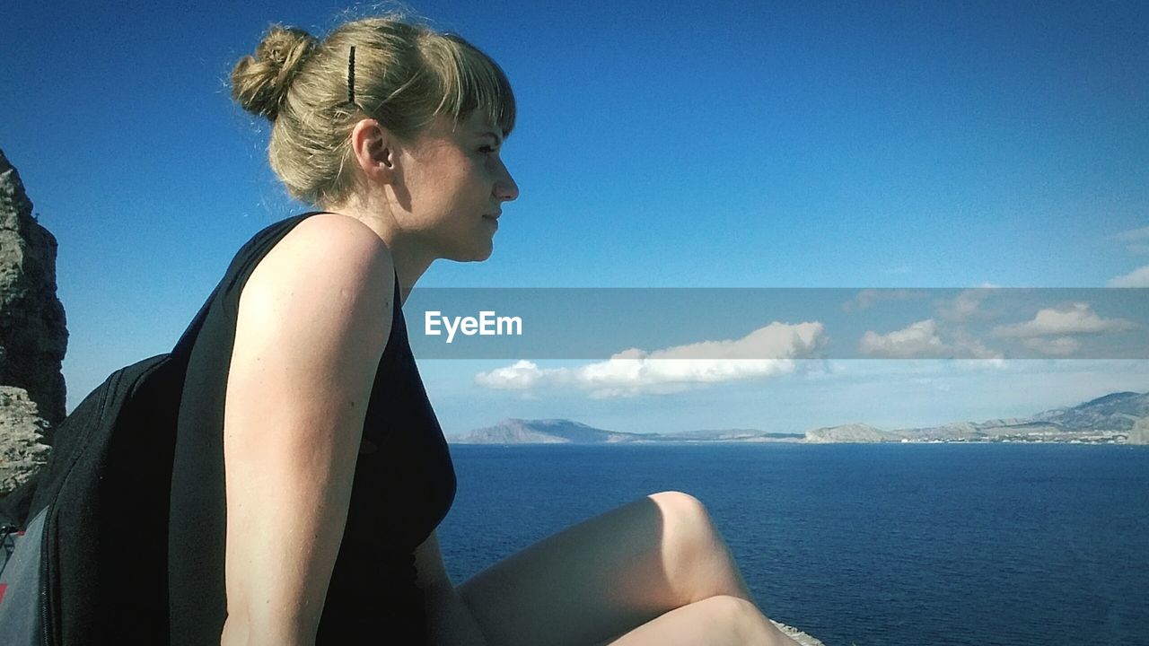 Side view of young woman looking at sea