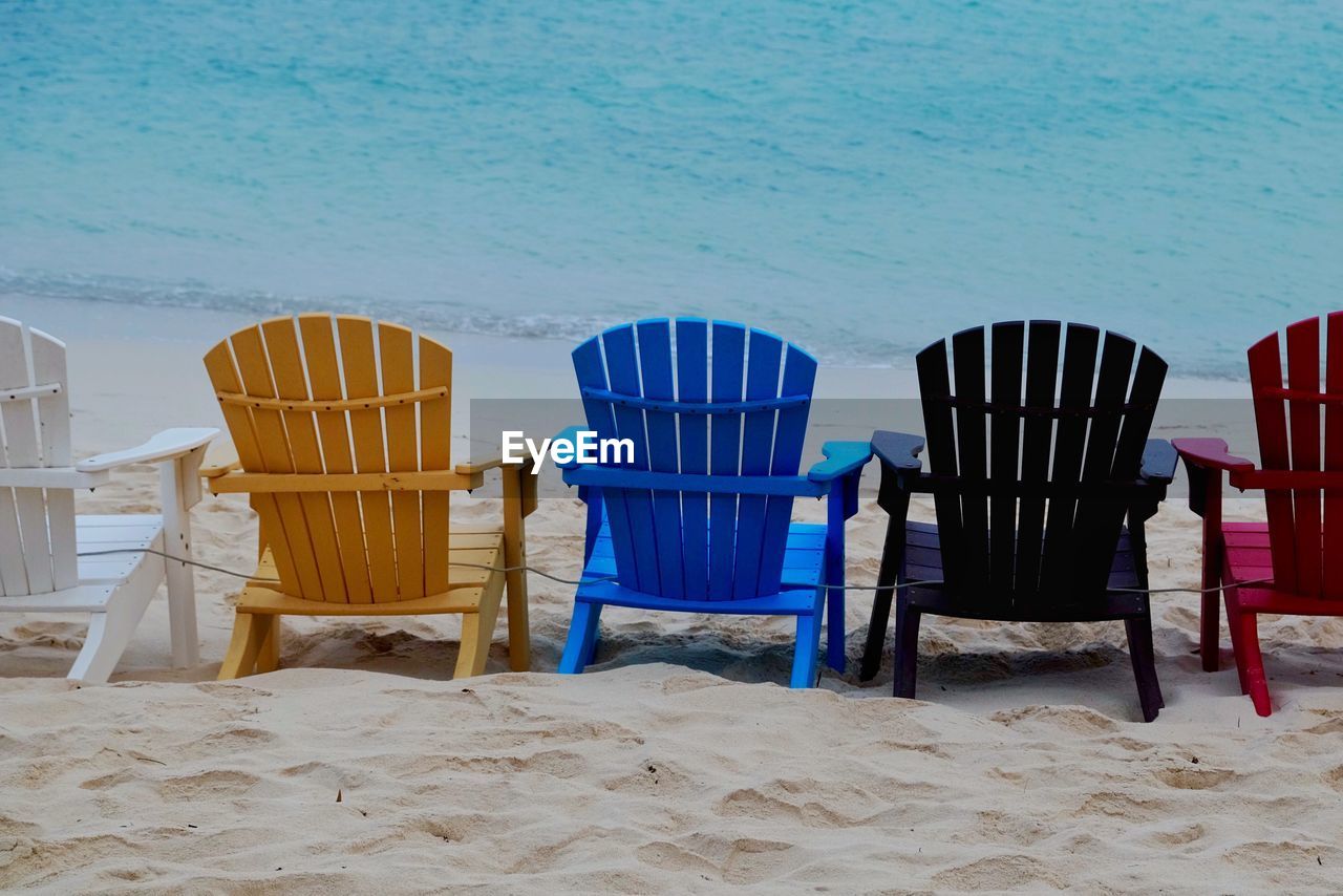 Colorful chairs arranged on shore at beach