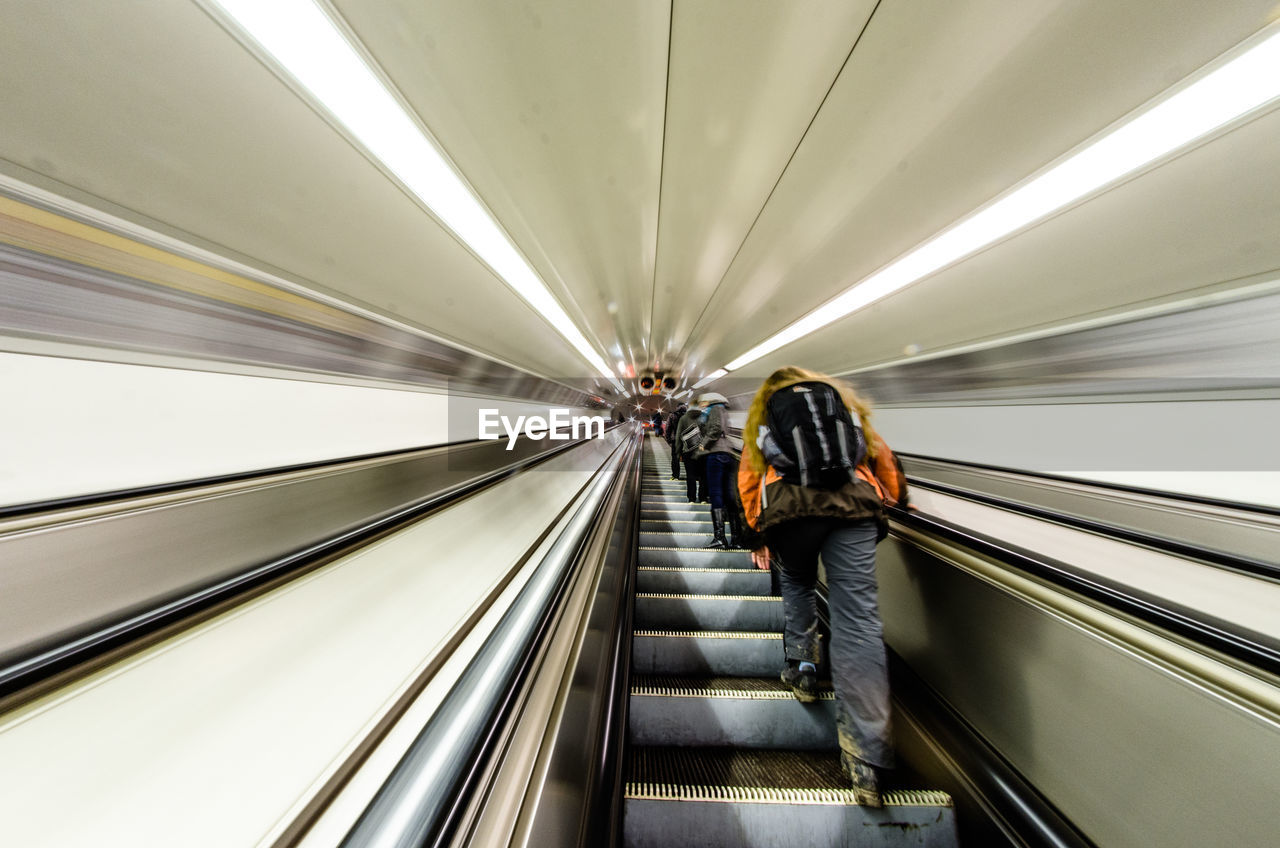 Rear view of man on escalator at subway station