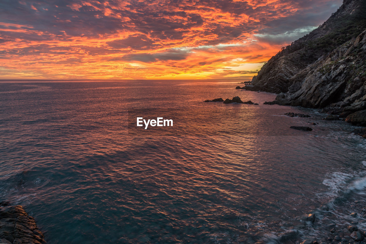 Scenic view of sea against orange sky