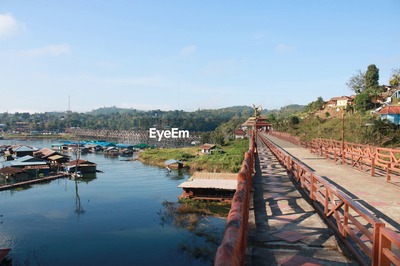 Scenic view of river by buildings against sky