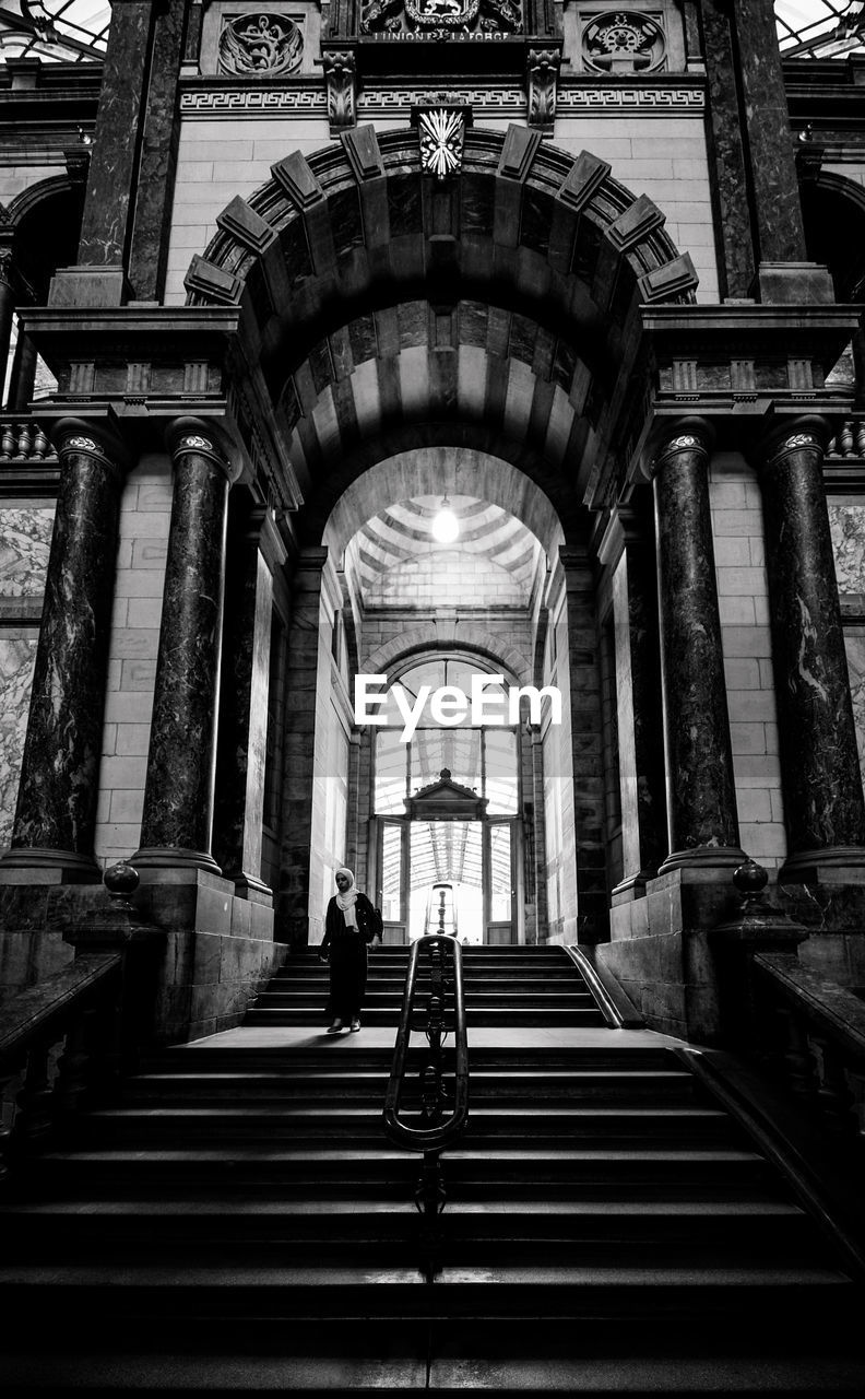 Woman walking in antwerp central station in black and white