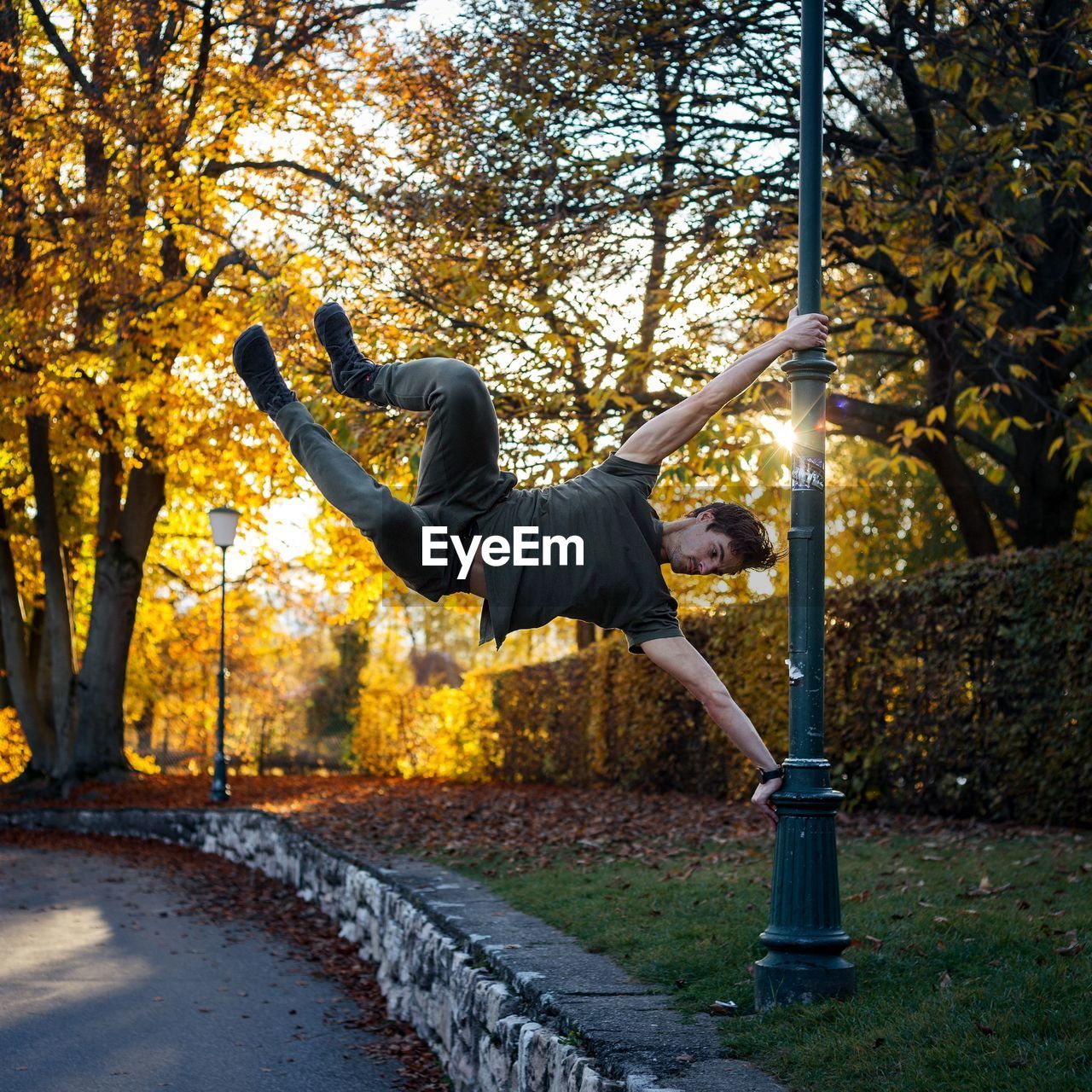 Full length of man hanging on pole during autumn