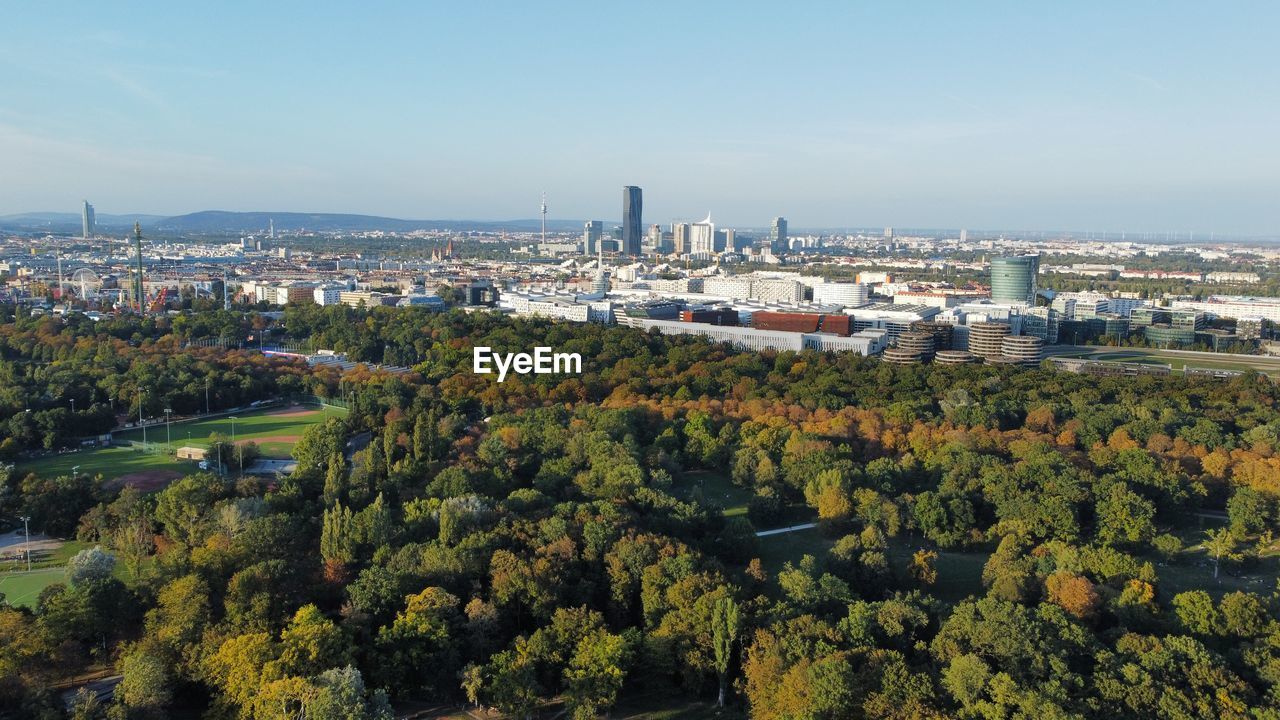 HIGH ANGLE VIEW OF TREES BY BUILDINGS AGAINST SKY