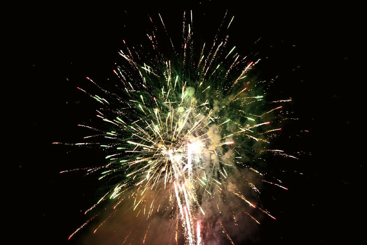 Low angle view of firework exploding in sky at night