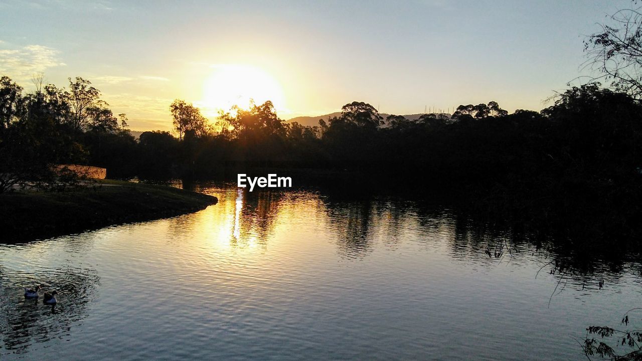 SCENIC VIEW OF LAKE BY SILHOUETTE TREES AGAINST SKY