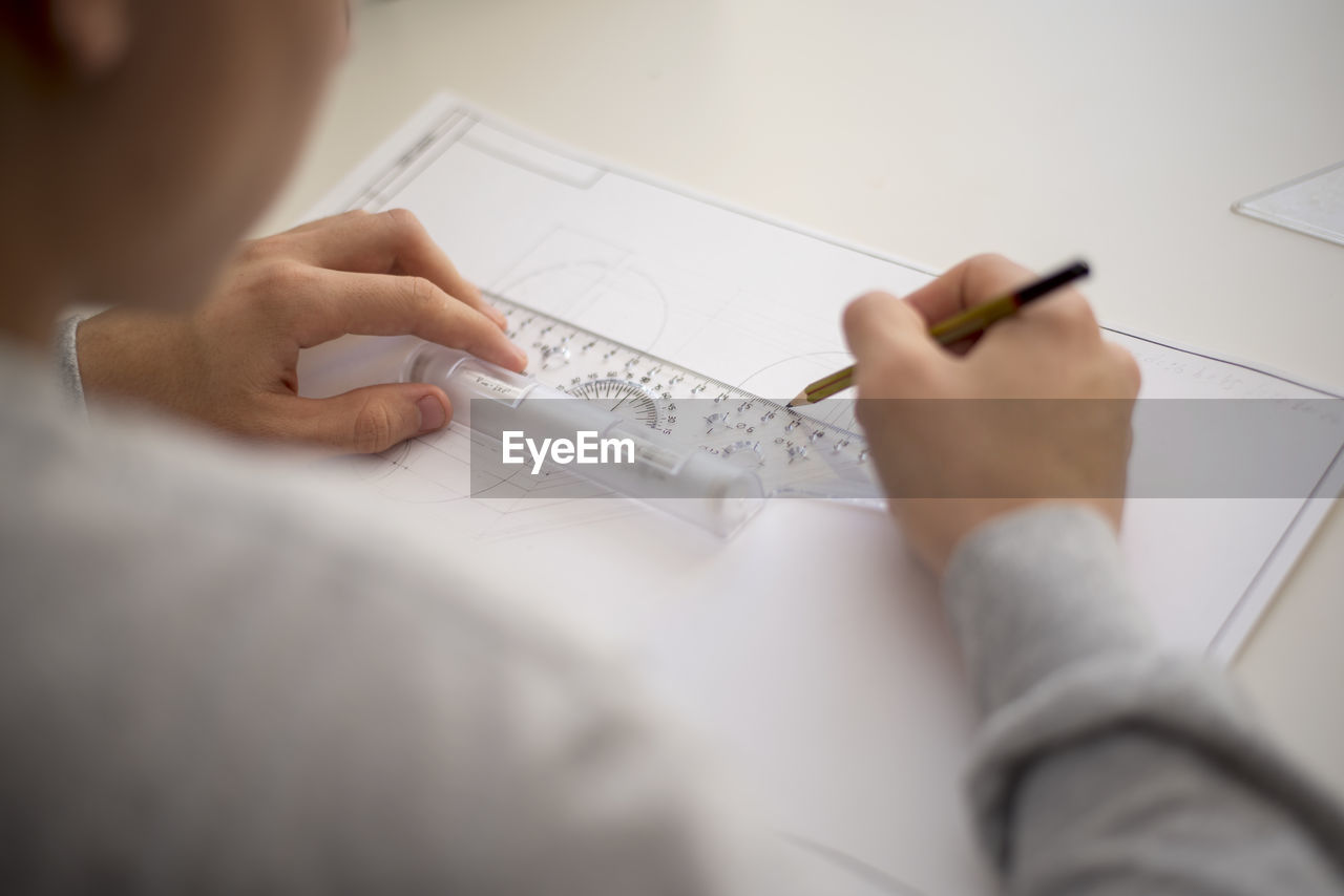 Close-up of architect working over blueprint on table at office