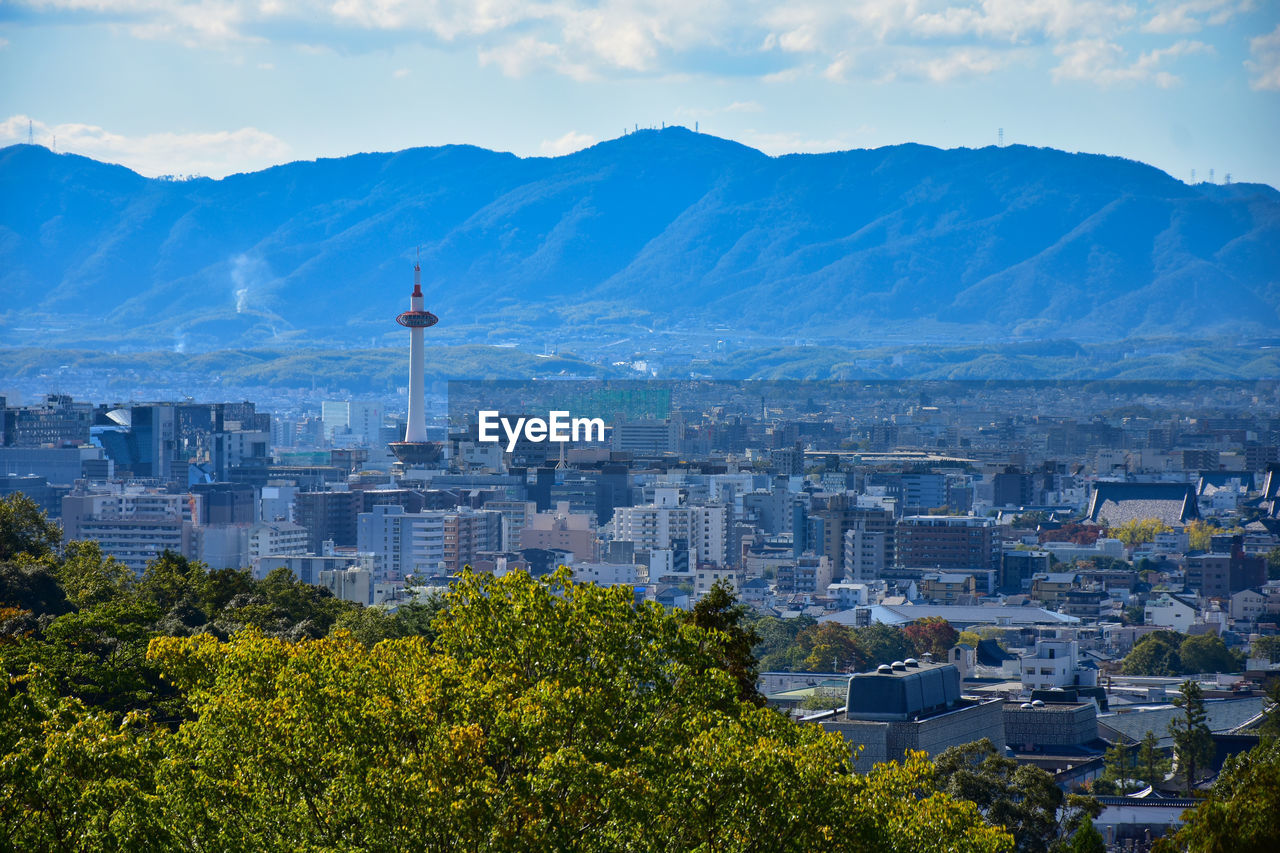 SCENIC VIEW OF CITY BY MOUNTAINS AGAINST SKY