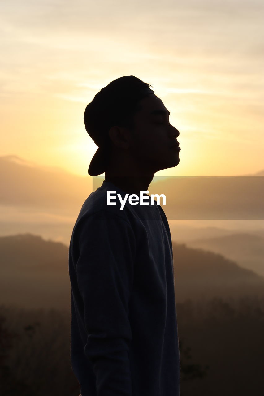 Silhouette man standing against sky during sunset
