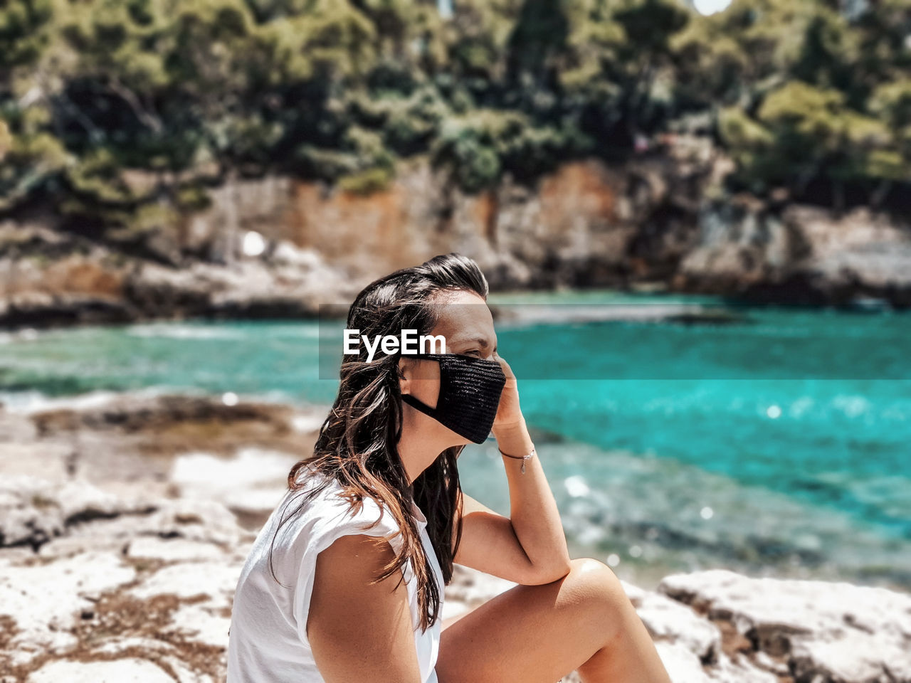 Young woman wearing black mask at beach. summer, tourism, virus, corona, covid-19.