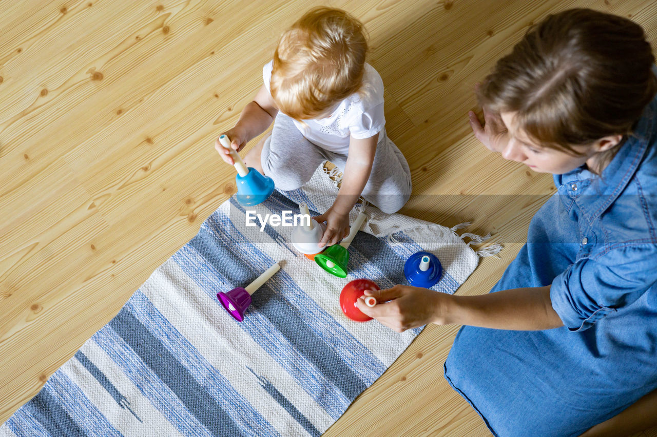 High angle view of boy with toy on floor