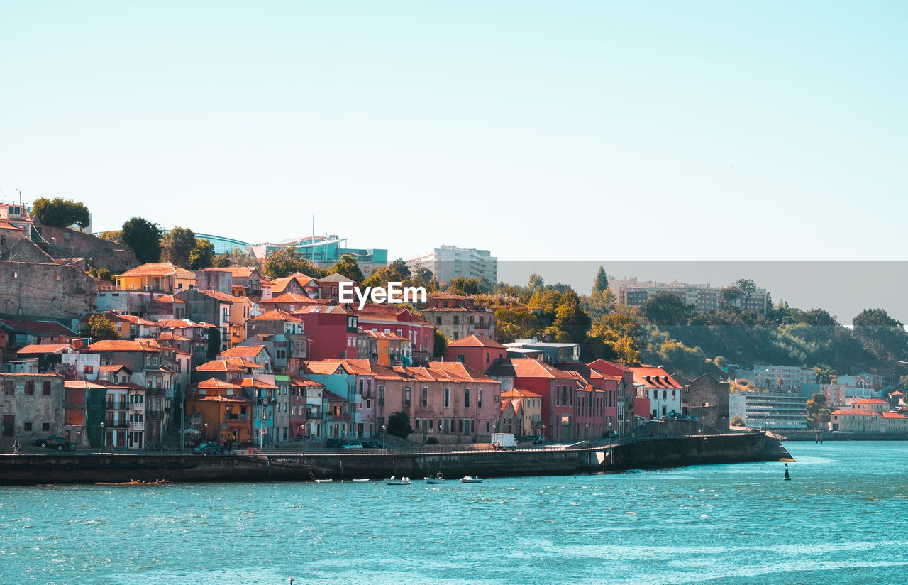 SEA BY BUILDINGS AGAINST CLEAR SKY