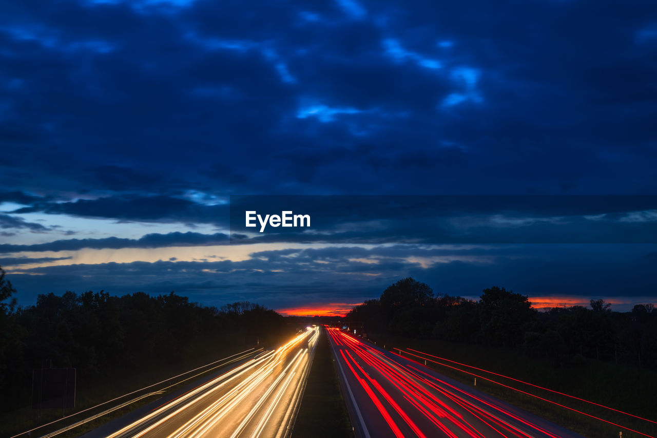 LIGHT TRAILS ON HIGHWAY AT DUSK