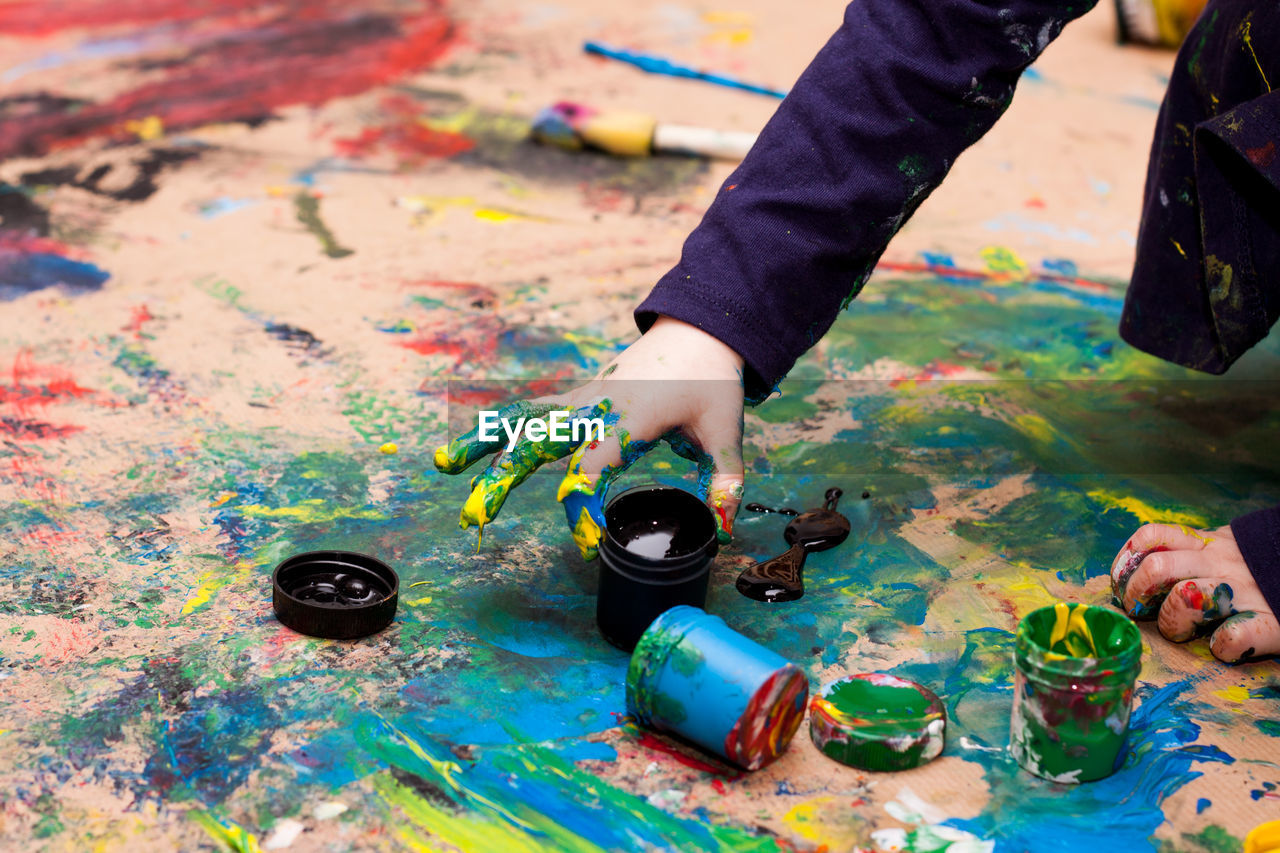 Little girl painting with hands 