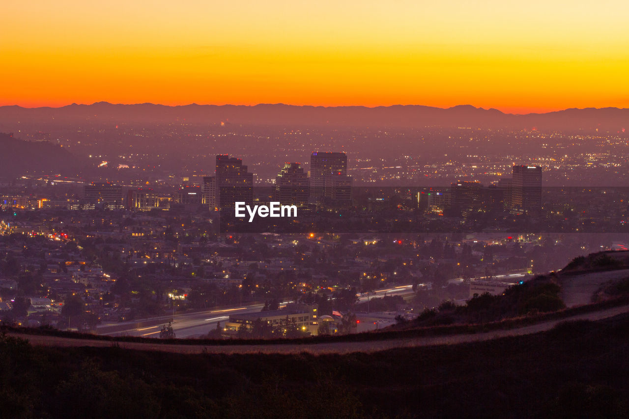 View of downtown glendale ca at sunset. fireworks can be seen in the distance.