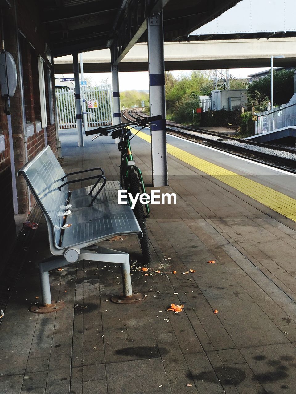 View of bench and bicycle at railroad station platform