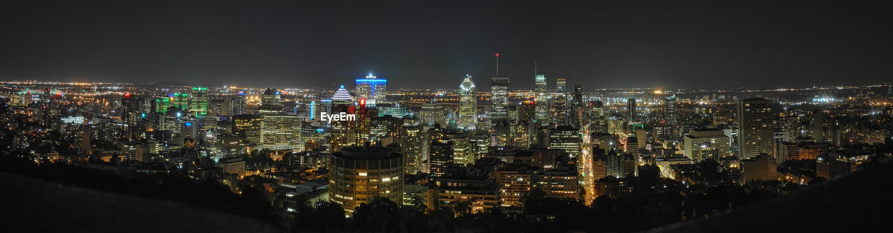 Illuminated cityscape against sky at night