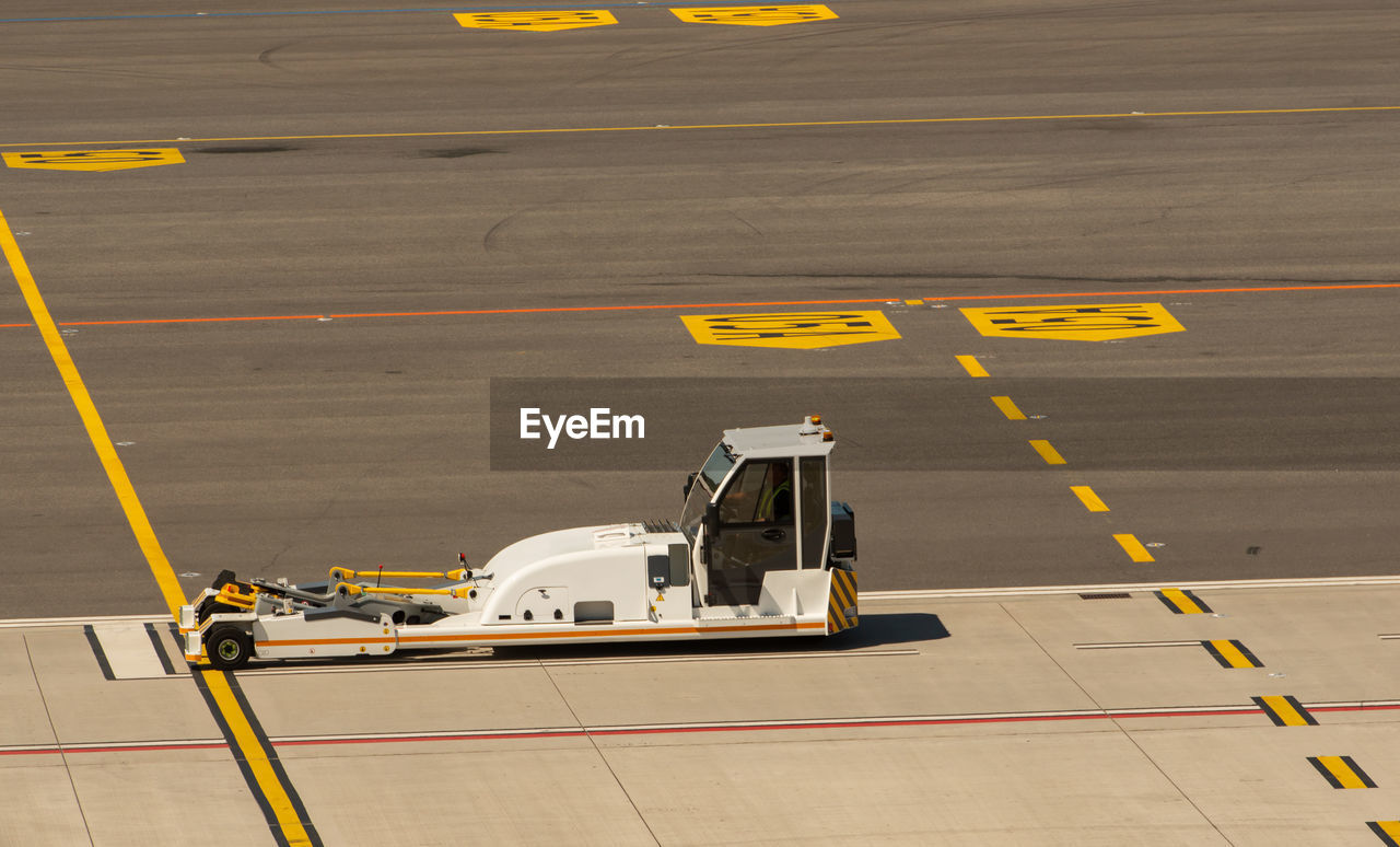 HIGH ANGLE VIEW OF YELLOW AIRPLANE ON RUNWAY