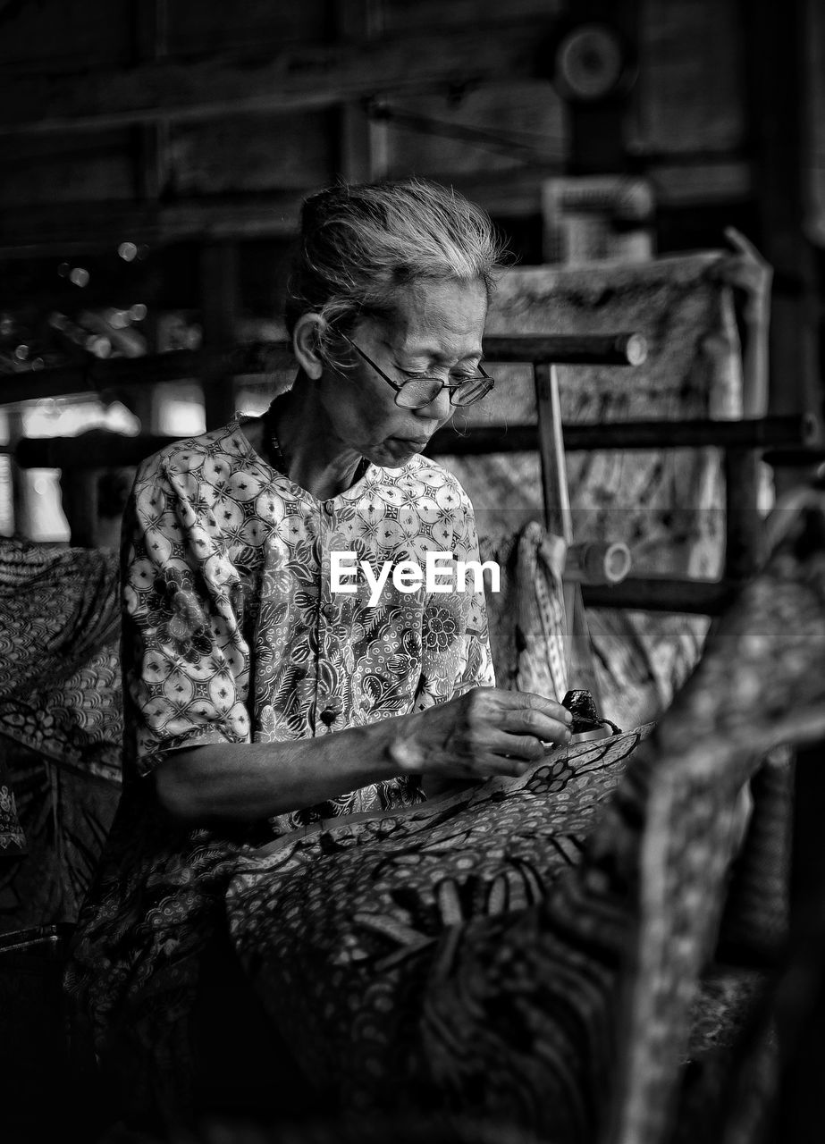 Woman making design on textile at home