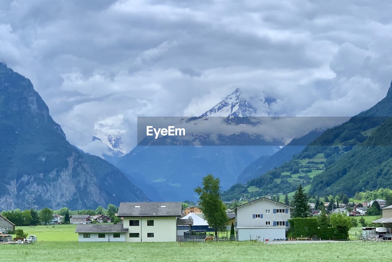 Houses on mountain against sky