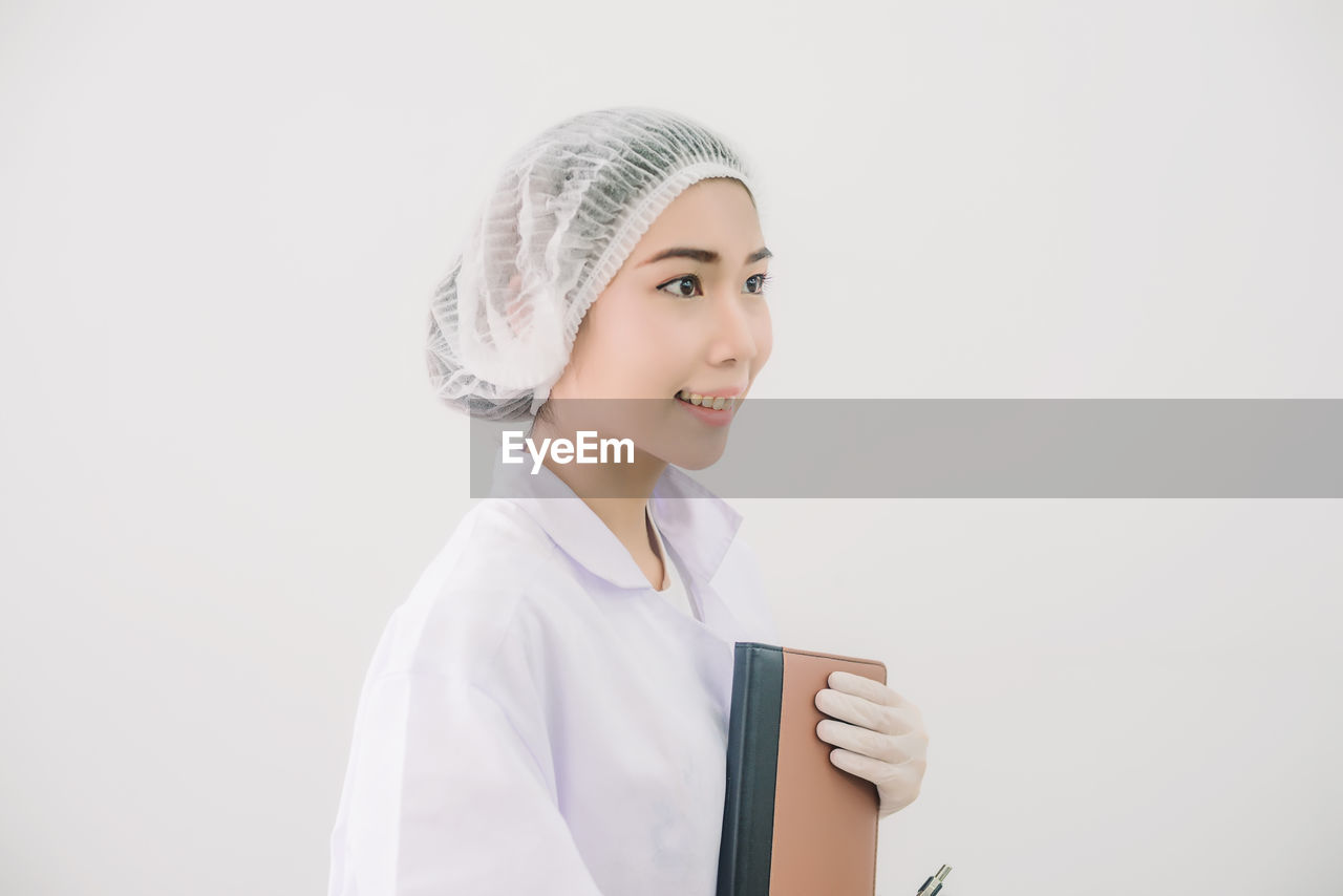 Smiling female doctor against white background