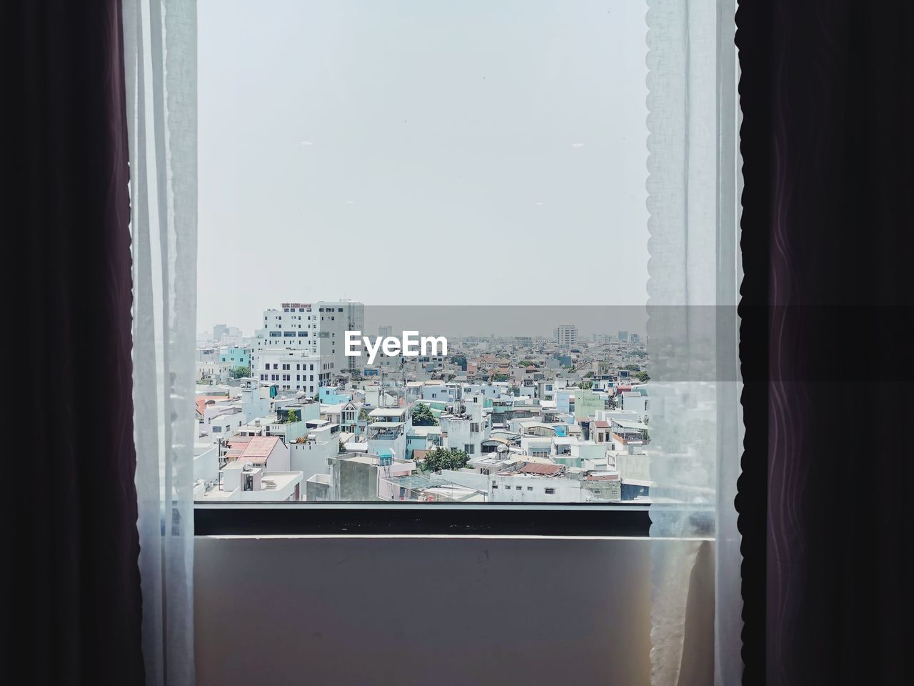 CITY SEEN THROUGH GLASS WINDOW