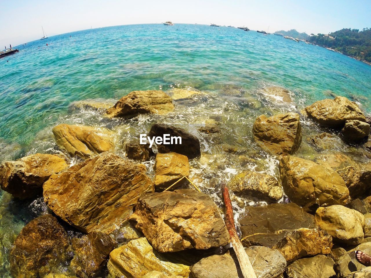 CLOSE-UP OF ROCKS AT SHORE AGAINST SKY