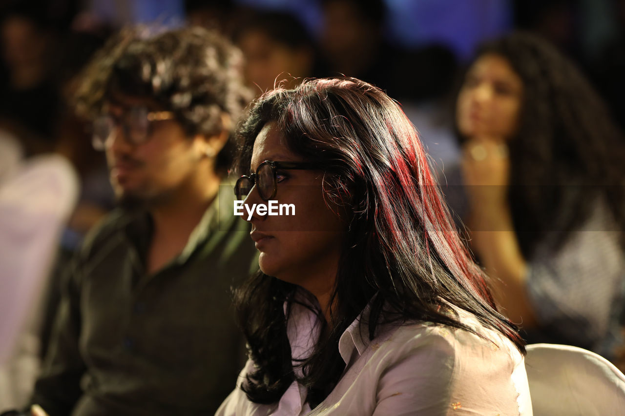 crowd, audience, group of people, adult, fashion, women, young adult, arts culture and entertainment, looking, togetherness, focus on foreground, sitting, indoors, portrait, watching, performance, emotion, female, glasses, music, men, friendship