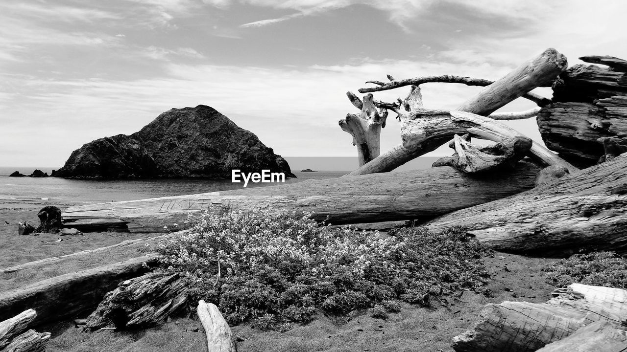 ROCKS ON BEACH AGAINST SKY