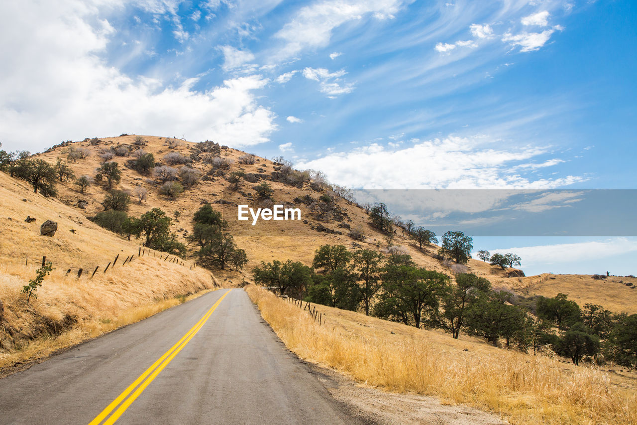 Road by mountain against sky