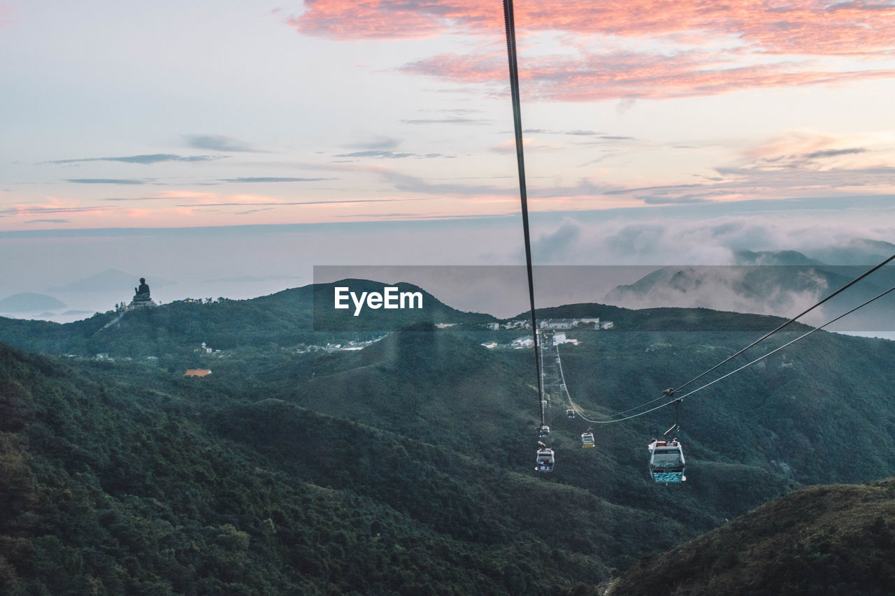 Overhead cable car over mountains against sky