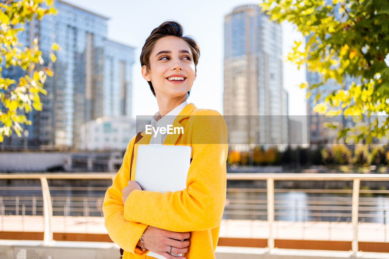 portrait of young woman standing against building