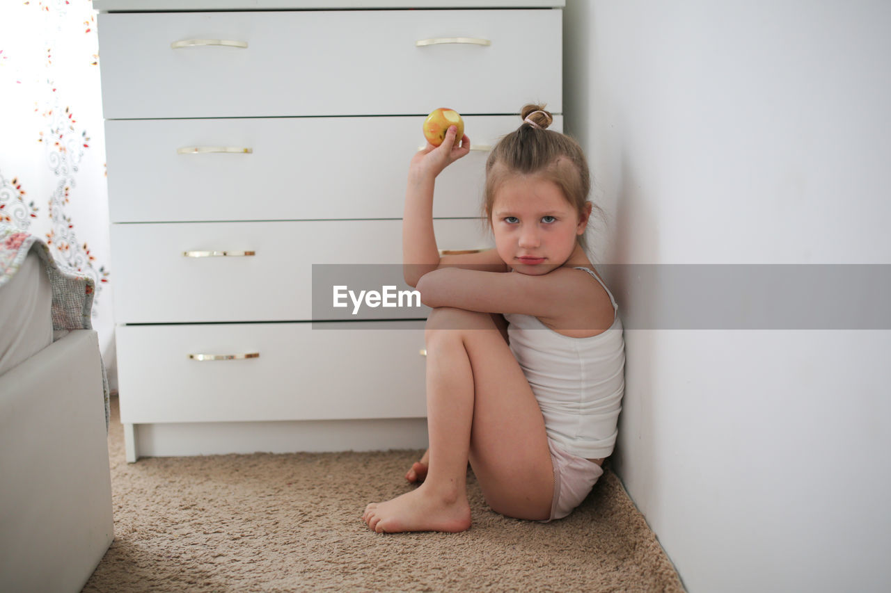 Funny offended child girl, light background, real interior. concept childhood and emotions.