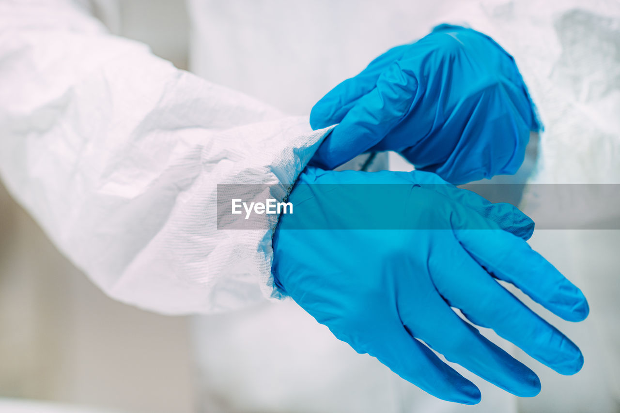 Woman putting protective splash face shield on. laboratory safety equipment.