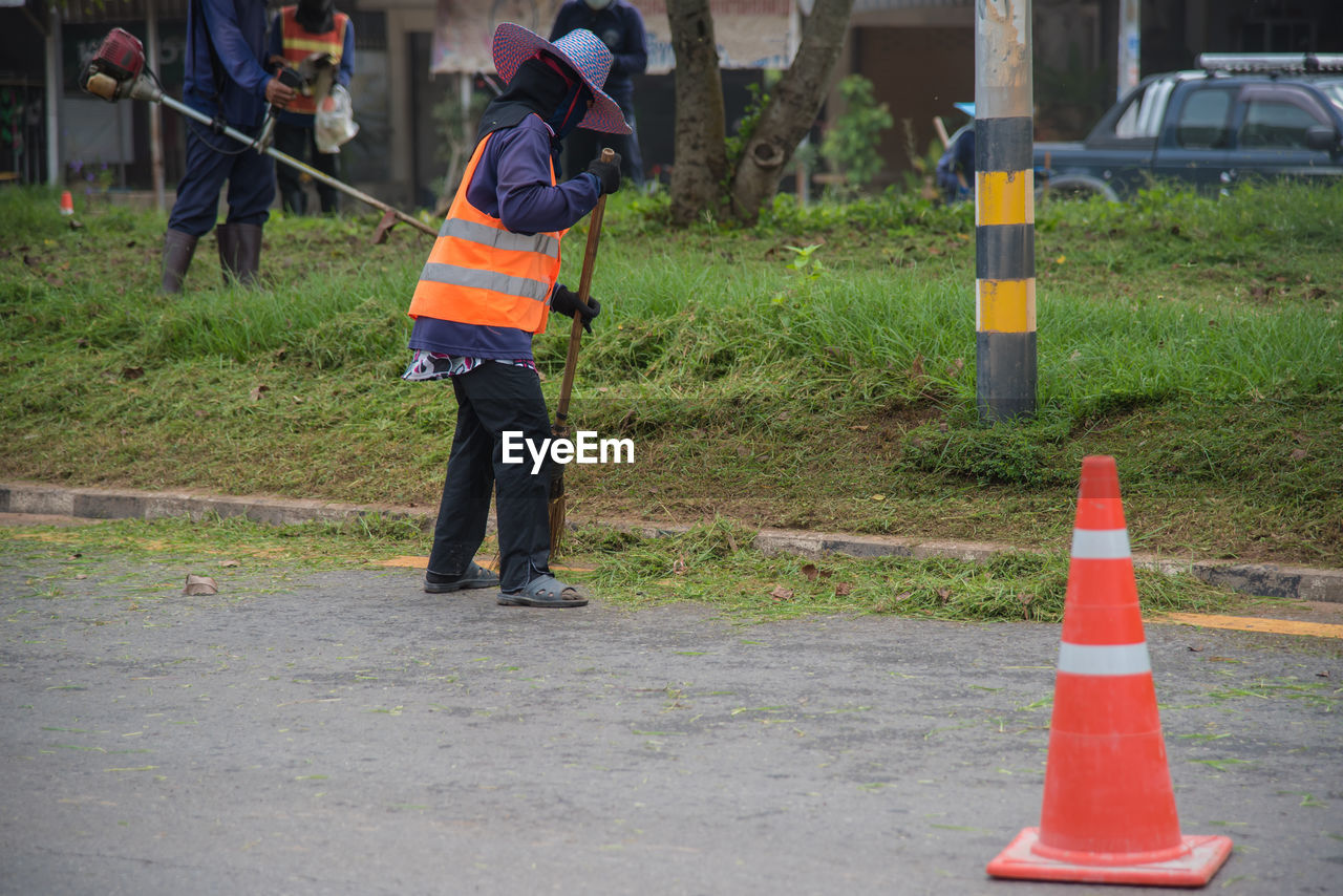 Full length of man sweeping road