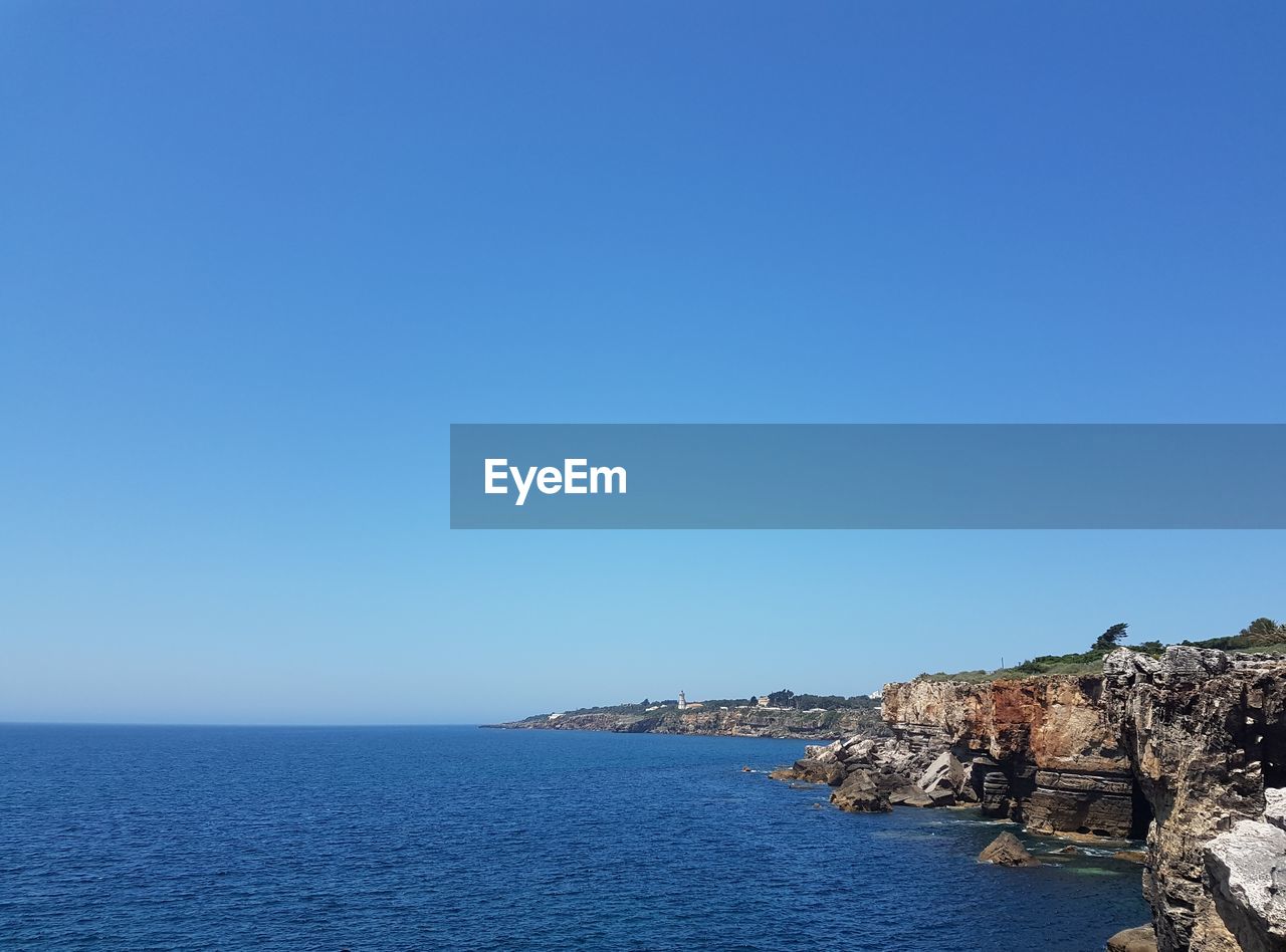 Scenic view of sea against clear blue sky