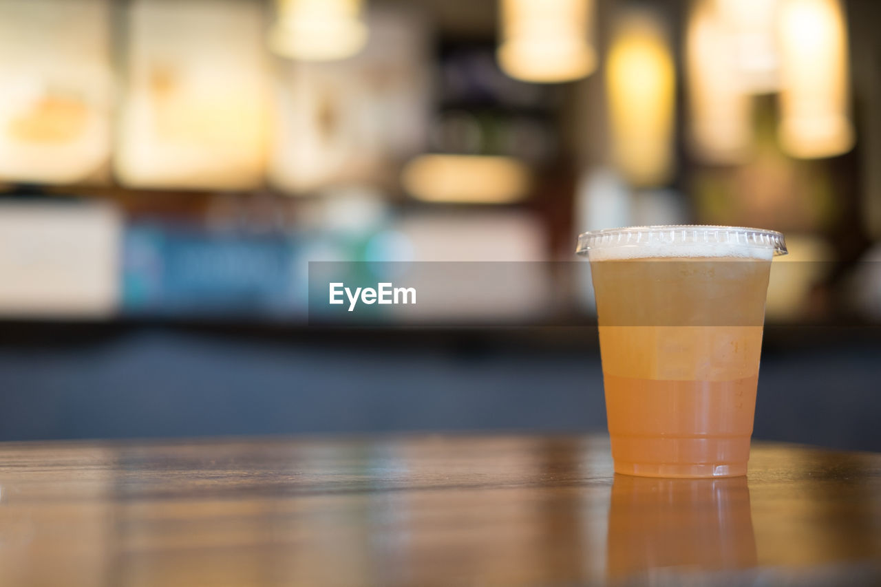 CLOSE-UP OF BEER GLASS ON TABLE AT HOME