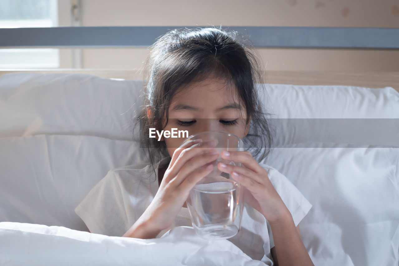 Girl drinking water while relaxing at home