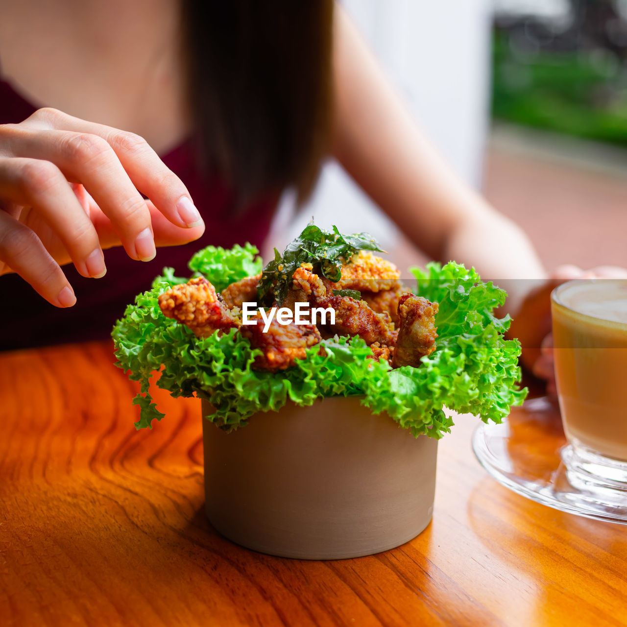 Midsection of woman reaching out to a bowl of food