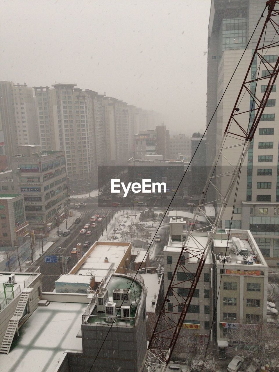 High angle view of cityscape during snow fall