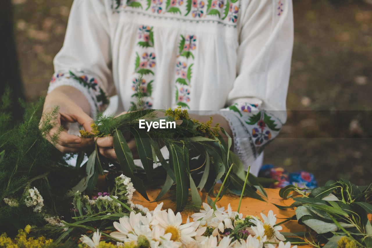 MIDSECTION OF PERSON HOLDING BOUQUET OF FLOWER