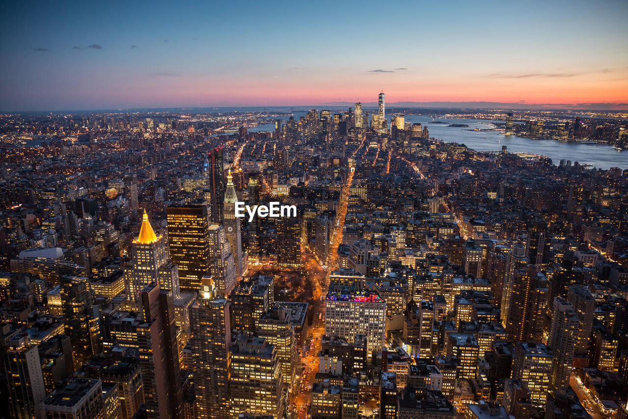 Aerial view of city lit up at sunset