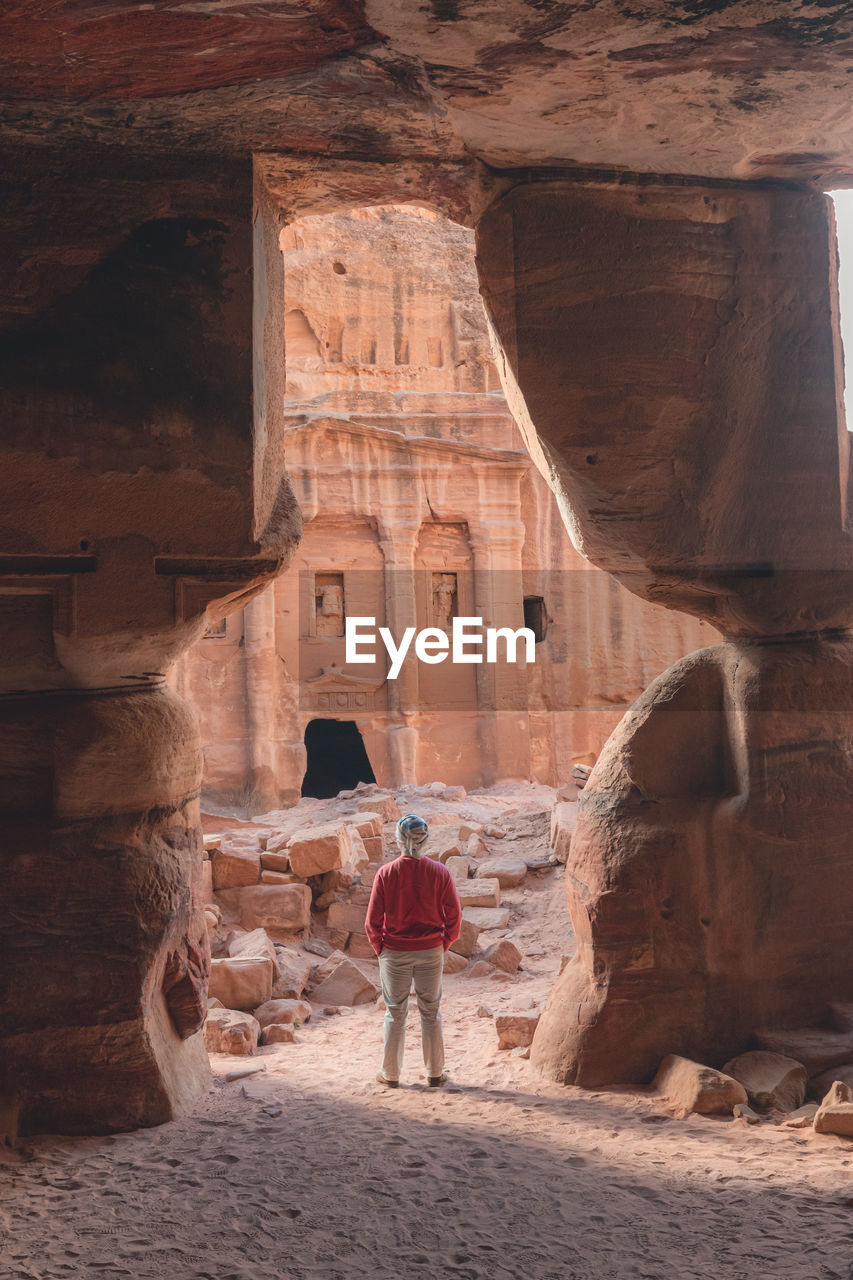 Man standing in rock opening at petra.