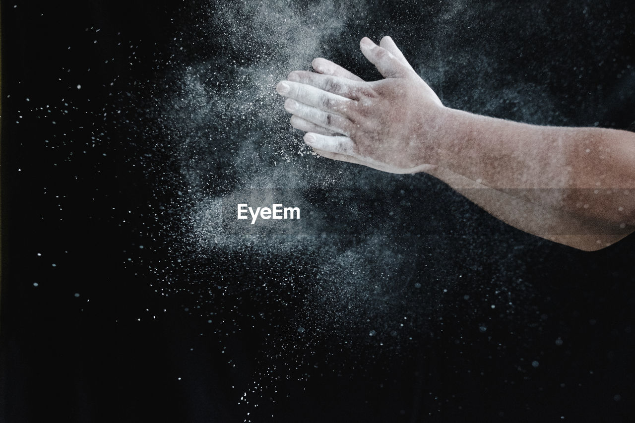 CLOSE-UP OF PERSON HAND AGAINST GRAY BACKGROUND