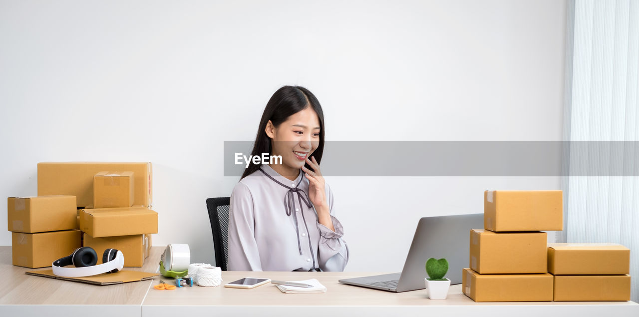 Cheerful woman looking at laptop while sitting at office
