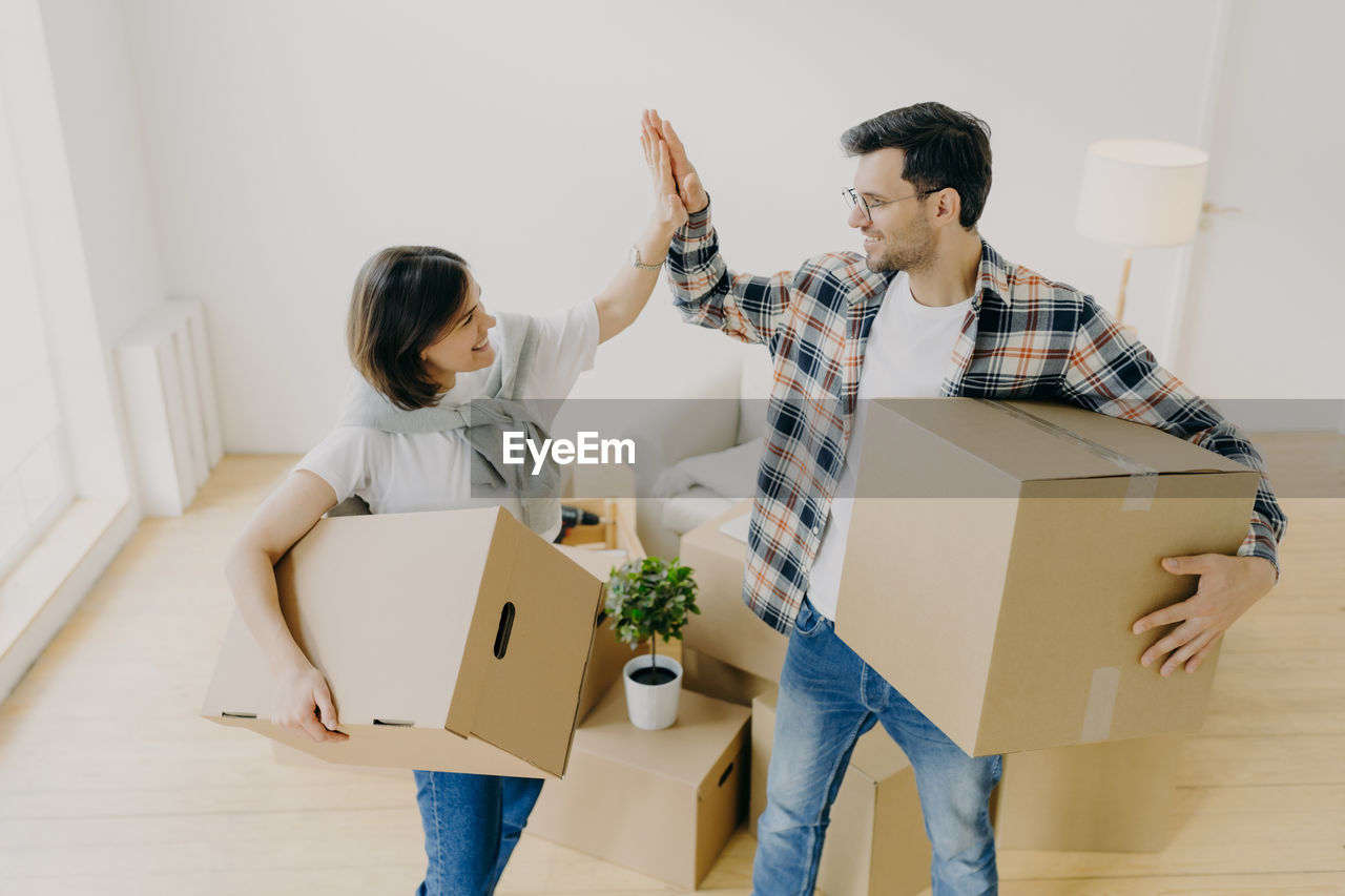 Couple holding boxes on home
