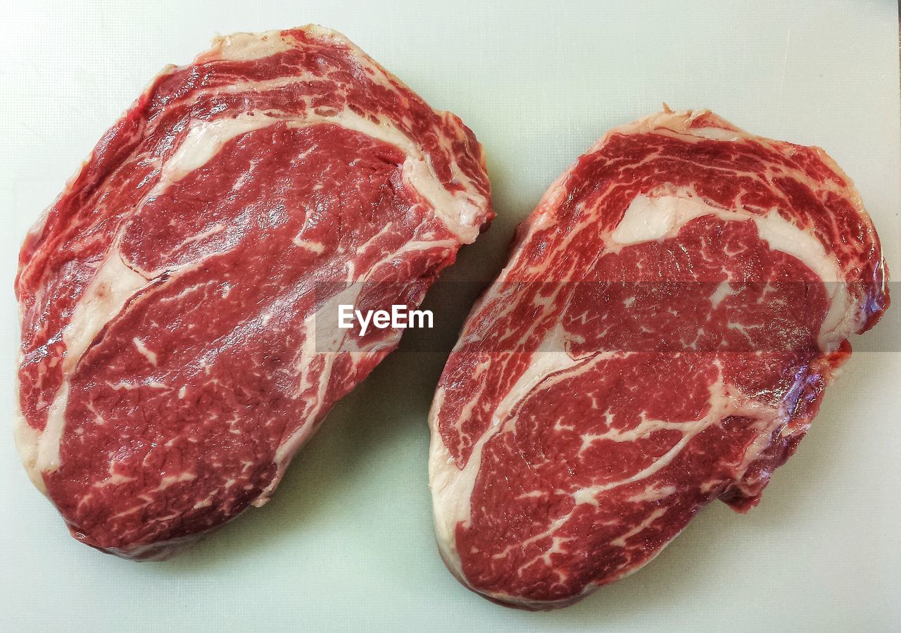 Close-up of raw beef steaks on table