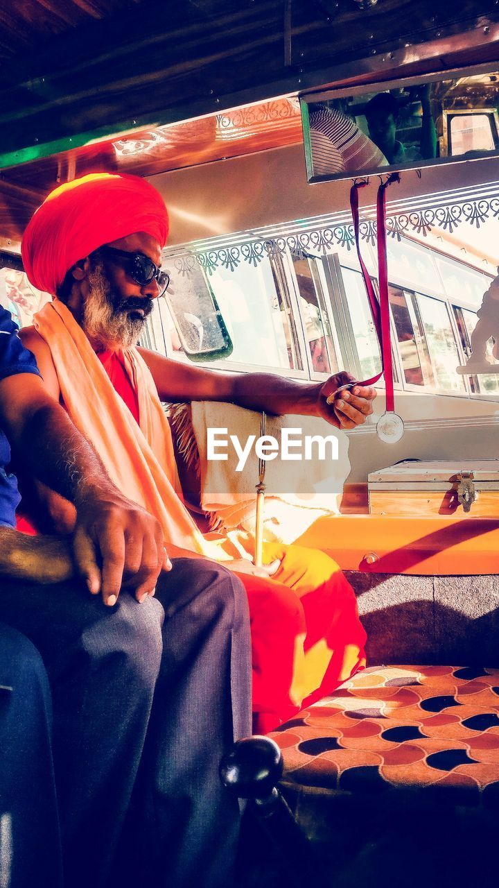 Man in traditional clothes sitting in bus